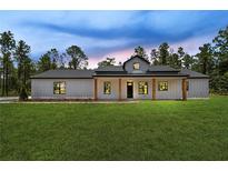 Beautiful single-story home featuring a modern farmhouse design and inviting front porch with wood columns at 12193 Sw 69 Pl, Ocala, FL 34481