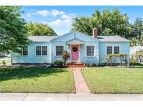 Charming single-Gathering home featuring a beautiful lawn, brick walkway, and eye-catching pink door at 1225 W Smith St, Orlando, FL 32804
