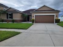 Charming single-story home featuring a well-maintained lawn and a two-car garage at 12845 Sawgrass Pine Cir, Orlando, FL 32824