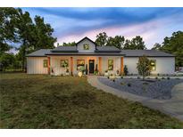 Charming single-story home with modern farmhouse design, inviting front porch, and meticulous landscaping at 13393 Sw 484 Hwy, Ocala, FL 34481