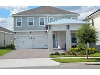 Charming two-story home with a two car garage, complemented by a well-manicured lawn and inviting front porch at 14955 Lebeau Loop, Winter Garden, FL 34787