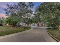Charming home featuring a circular driveway and lush landscaping with mature trees for enhanced curb appeal at 205 Elaine Pl, Chuluota, FL 32766