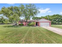 Charming single-story home with mature trees and a lush green lawn at 2409 Pinyon Ct, Kissimmee, FL 34746