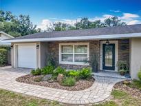 Charming single-story home featuring stone accents, a front-entry garage, and lush landscaping at 2550 Meadowview Ln, Deland, FL 32720