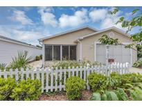 Charming single-story home featuring a welcoming screened lanai and a neat white picket fence at 2714 Moncayo Ave, The Villages, FL 32162
