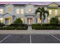 Charming townhouse with colorful facade, landscaped yard, and welcoming front entrance at 2920 On The Rocks Pt, Kissimmee, FL 34747