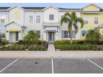 Charming townhouse with colorful facade, landscaped yard, and welcoming front entrance at 2920 On The Rocks Pt, Kissimmee, FL 34747