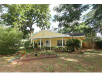 Charming yellow home with well-maintained lawn and mature landscaping, creating a welcoming curb appeal at 317 White Oak Dr, Altamonte Springs, FL 32701