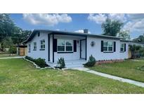 Charming single-story home with white paint, dark shutters and new landscaping at 331 N Dollins Ave, Orlando, FL 32805