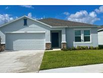 Charming single-story home with a two-car garage, well-manicured lawn and neutral paint at 33836 Sky Blossom Cir, Leesburg, FL 34788