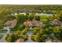 Expansive estate with meticulously landscaped grounds, tile roof, and a serene lake view at 3512 Legacy Hills Ct, Longwood, FL 32779