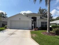 Charming single-story home featuring a well-manicured lawn and a neutral-colored exterior at 5560 Squires Dr, Leesburg, FL 34748