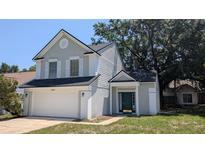 Charming two-story home featuring a two-car garage, gray stucco and dark green door at 609 Whittingham Pl, Lake Mary, FL 32746