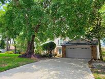 Charming two-story home with a brick garage and mature landscaping in a serene, tree-filled neighborhood at 983 Bucksaw Pl, Longwood, FL 32750