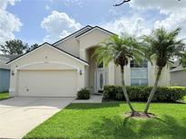 Charming single-Gathering home with a two-car garage, well-manicured lawn, and tropical palm trees at 12756 Maribou Cir, Orlando, FL 32828