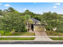 Charming single-story home featuring a brick driveway, lush landscaping, and a two-car garage at 1601 Stargazer Ter, Sanford, FL 32771