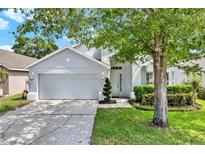 Charming home with a manicured lawn and a two-car garage, nestled under the shade of a mature tree at 2776 Joseph Cir, Oviedo, FL 32765