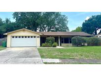 Charming single-story home featuring a two-car garage and a well-maintained lawn with mature landscaping at 4105 Quando Dr, Belle Isle, FL 32812