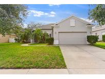 Charming single-story home boasts a lush lawn, mature trees, and a two-car garage at 4520 Barrister Dr, Clermont, FL 34711