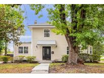 Charming two-story home with black front door, manicured landscaping and mature trees at 490 Shoreview Ave, Winter Park, FL 32789
