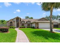 Charming single-Gathering home with brick accents, lush lawn, and a curved brick walkway leading to the front door at 513 Sabal Trail Cir, Longwood, FL 32779
