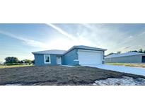 A charming single-story home with a well-manicured lawn, light-blue exterior and a two-car garage at 534 Central Ave, Frostproof, FL 33843