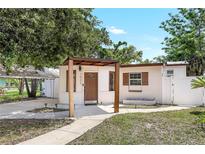 Charming home with a pergola covered front porch and well-maintained lawn at 1032 Perkins Rd, Orlando, FL 32809