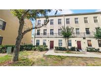 Three story townhouse with a landscaped front yard with a walkway to the front door at 1038 Waterside Dr, Celebration, FL 34747