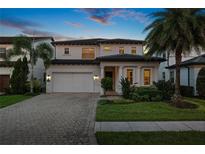 Beautiful two story home featuring a brick driveway, meticulous landscaping, and a two car garage at 10529 Royal Cypress Way, Orlando, FL 32836