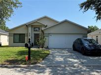 Inviting single-story home featuring a two-car garage, well-maintained lawn, and welcoming curb appeal at 1112 Winding Water Way, Clermont, FL 34714