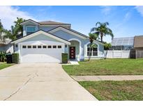 Charming two-story home featuring an attached garage and well-manicured lawn at 11836 Hartfordshire Way, Orlando, FL 32824