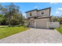 Charming two-story home with a well-maintained front yard and a brick-paved driveway leading to the garage at 146 E 15Th St, Apopka, FL 32703