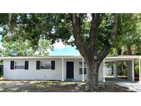 Charming single-story home featuring a carport and a lush, shady tree in the front yard at 205 Brighton Way, Casselberry, FL 32707
