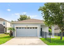 Charming single-story home with a gray exterior, attached garage, and well-maintained lawn at 2125 Shackley Pl, Apopka, FL 32703