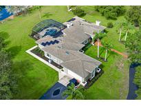 Expansive aerial view of a home featuring a screened pool, solar panels, lush landscaping, and a long driveway at 2326 Florida Ave, Oviedo, FL 32765