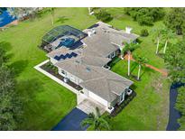 Stunning aerial view of a spacious single-story home with a screened pool, solar panels, and lush landscaping at 2326 Florida Ave, Oviedo, FL 32765