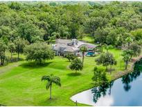 Stunning aerial view of a lush property with a large home, pool, pond, and lots of beautiful trees at 2326 Florida Ave, Oviedo, FL 32765