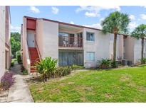 Inviting condo exterior featuring a private balcony, lush landscaping, and vibrant green lawn at 2486 Citrus Club Ln # 408, Orlando, FL 32839