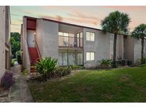 Inviting condo exterior featuring a private balcony, lush landscaping, and vibrant green lawn at 2486 Citrus Club Ln # 408, Orlando, FL 32839