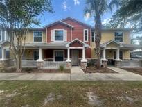 Charming townhouse featuring a cozy front porch with stone accents and a well-maintained lawn at 4650 Staghorn Dr # 500, Orlando, FL 32808