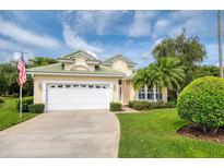 Charming home with a green tile roof, lush landscaping, and a spacious two-car garage at 487 Foxhill Dr, Debary, FL 32713