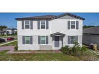 Charming two-story home with gray siding, stone accents, and well-maintained landscaping, offering great curb appeal at 596 Sun Warbler Way, St Cloud, FL 34771