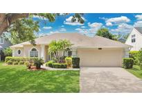 Charming single-story home with lush landscaping and a well-manicured lawn at 7900 Saint Giles Pl, Orlando, FL 32835