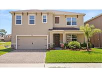 Charming two-story home with a two-car garage, manicured lawn, and beautiful landscaping at 850 Lazio Cir, Debary, FL 32713