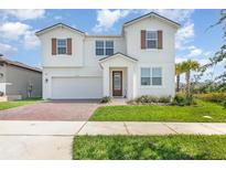 Charming two-story home with a well-manicured lawn, brick driveway and warm wood accents, offering great curb appeal at 9027 Coral Cape St, Kissimmee, FL 34747