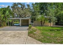 Inviting exterior view of a charming single-story home with a covered carport, driveway, and lovely landscaping at 11 Plumosa Ave, Casselberry, FL 32707