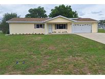 Charming single-story home with a well-manicured lawn and a two-car garage at 11282 Sw 62Nd Avenue Rd, Ocala, FL 34476