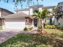 Charming two-story home featuring a stone facade, well-manicured lawn, and an attached two-car garage at 13156 Hatherton Cir, Orlando, FL 32832