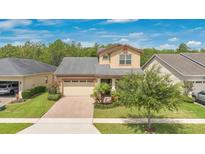 Charming two-story home featuring a well-manicured lawn, brick driveway, and inviting curb appeal at 14078 Alafaya Oak Bnd, Orlando, FL 32828