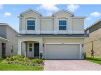 Charming two-story home boasts a well-manicured lawn and a brick driveway leading to a two-car garage at 14655 Erice Ave, Clermont, FL 34714